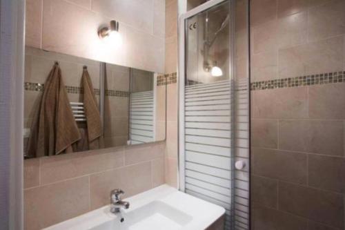 La salle de bains est pourvue d'un lavabo, d'un miroir et d'une douche. dans l'établissement Appartement confortable en plein coeur du Marais, à Paris