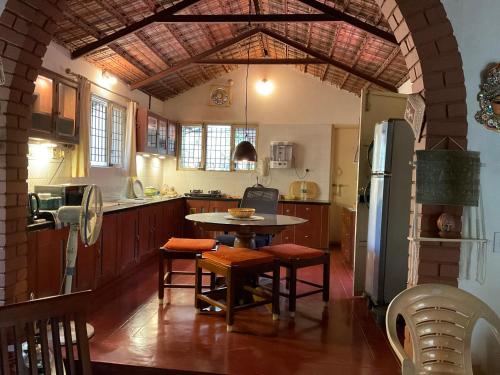 a kitchen with a table and a refrigerator at The Heritage Home Stay in Mysore