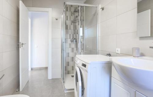 a white bathroom with a washing machine and a sink at Amazing Apartment In Orihuela With Wifi in Orihuela