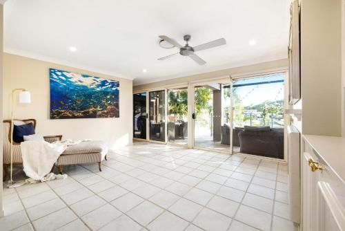a living room with a ceiling fan at Habourlights 5BR River Front Private Pool & Dock in Gold Coast