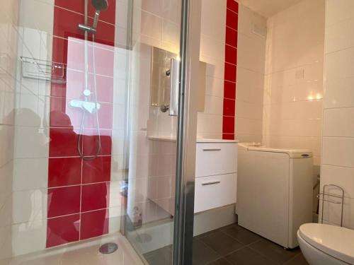 La salle de bains est pourvue d'une douche avec du carrelage rouge et blanc. dans l'établissement Grand Studio 4 Pers avec Terrasse et Parking Privé au Barcarès - FR-1-81-485, au Barcarès