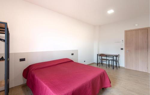 een slaapkamer met een rood bed en een tafel bij Amazing Apartment In Moscufo With Outdoor Swimming Pool in Moscufo