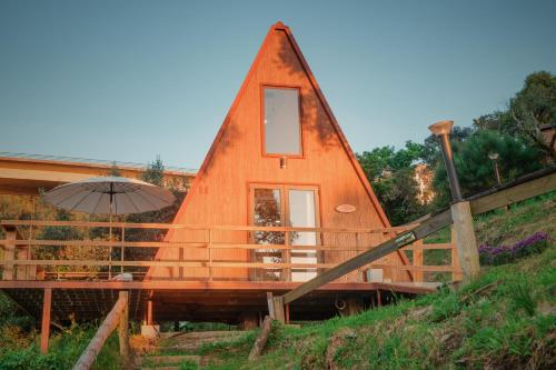 a tiny house is shown with an umbrella at Cabana Sobreiro in Castelo de Paiva