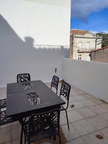 une table noire et des chaises au sommet d'un toit dans l'établissement Le Nid Tourbain, à Tourbes