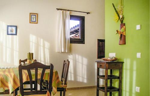 2 Bedroom Lovely Apartment In Villaviciosa في فيافيثيوسا: غرفة بطاولة وجدار أخضر