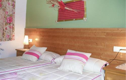 2 Bedroom Lovely Apartment In Villaviciosa في فيافيثيوسا: غرفة نوم مع سرير مع وسادتين