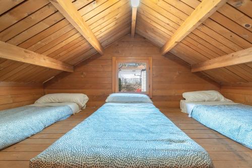3 Betten in einem Zimmer mit Holzdecken in der Unterkunft Barraca in Bárig