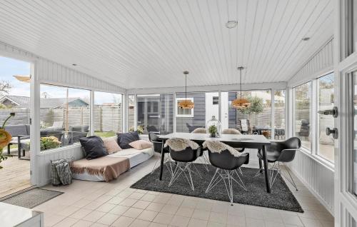 a screened in porch with a table and chairs at Amazing Home In Otterup With Kitchen in Otterup