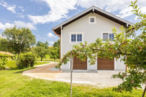 a white house with a wooden garage at Ferienhaus Waldherr in Waging am See