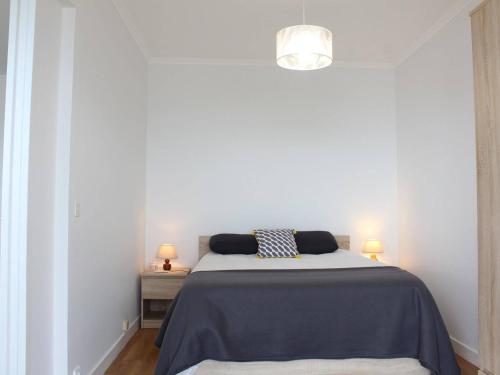 - une chambre blanche avec un lit et deux lampes dans l'établissement Appartement rénové face mer avec terrasse, box privatif, 2 pièces, 4 couchages - Pornichet - FR-1-245-132, à Pornichet