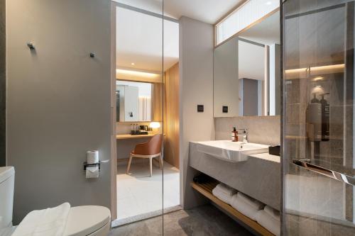 a bathroom with a sink and a toilet and a mirror at Saan Hotel Sathorn in Bangkok