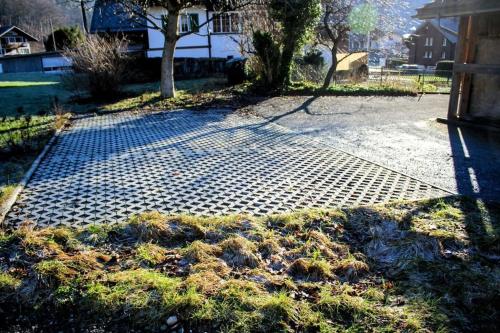 a patch of grass on the side of a driveway at Family-friendly chalet apt with balcony in Meiringen