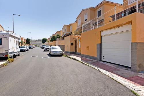 una calle con coches estacionados en el lateral de un edificio en Casa Rural Los Vencejos en Las Palmas de Gran Canaria