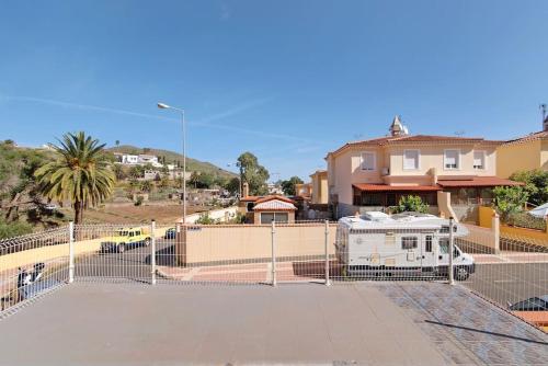 una valla frente a una casa con remolque en Casa Rural Los Vencejos en Las Palmas de Gran Canaria