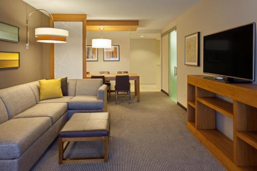 a living room filled with furniture and a tv at Hyatt Place Chicago Midway Airport in Bedford Park