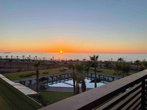 a sunset over the ocean from a balcony of a resort at 360 ocean view 2-bedroom lovely apartment in Tamaris