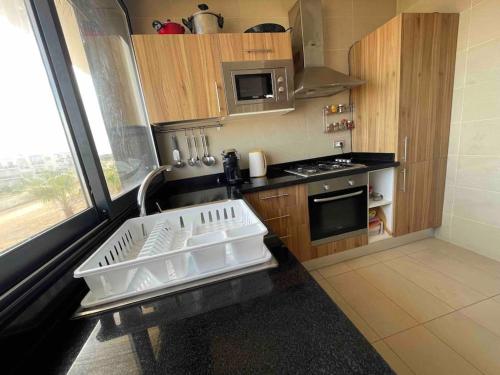 a small kitchen with a stove and a sink at 360 ocean view 2-bedroom lovely apartment in Tamaris