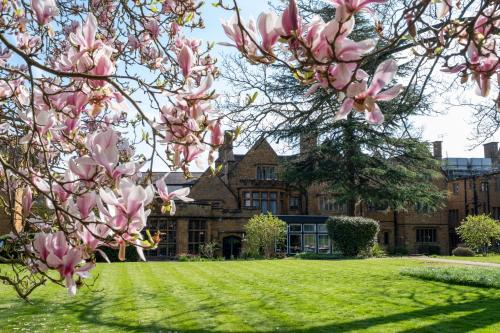 a magnolia tree in front of a building at Whately Hall Hotel in Banbury