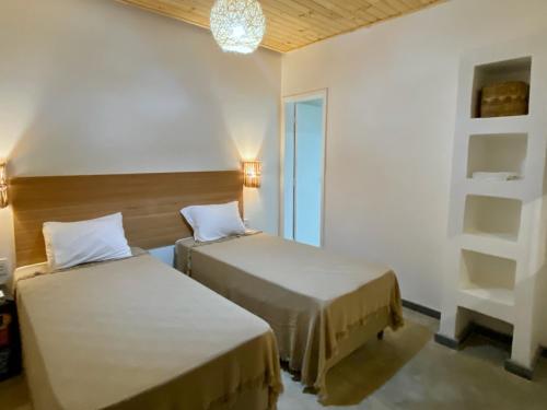 um quarto com duas camas e um lustre em Pousada Panorama Cipo em Santana do Riacho