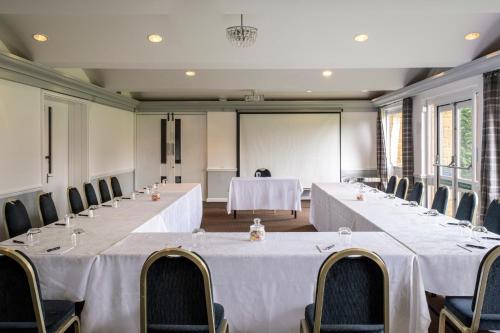 a row of tables in a room with chairs and tablesearcher at Whately Hall Hotel in Banbury