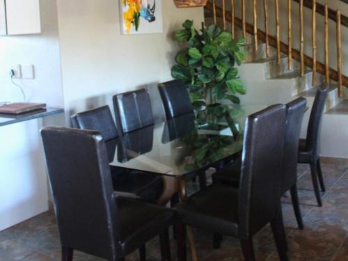 una mesa de comedor con sillas negras y una planta en Bushveld Venue, en Mabula
