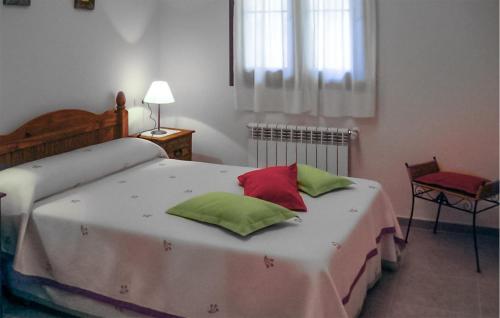 1 dormitorio con 1 cama con almohadas verdes y rojas en 2 Bedroom Amazing Apartment In Villaviciosa en Villaviciosa