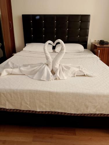 twee zwanen maken een hartvorm op een bed bij BALŞEN HOTEL in Anamur