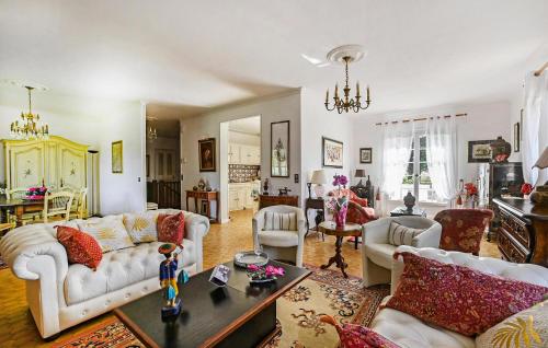 a living room with white couches and a table at Lovely Home In Saint-Julien-Les-Rosie in Saint Julien Les Rosiers