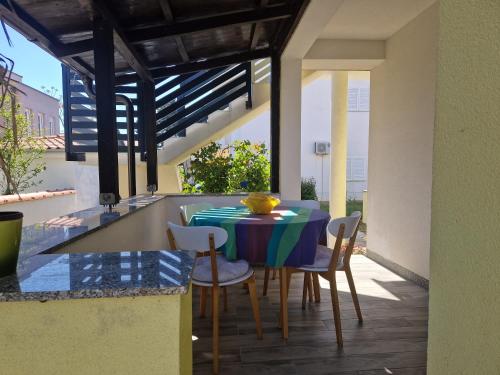 a kitchen with a table and chairs on a patio at Apartment Una s dvije terase in Privlaka