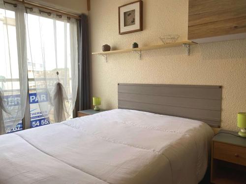 1 dormitorio con 1 cama blanca grande y ventana en Studio Balaruc-les-Bains, 1 pièce, 2 personnes - FR-1-553-80, en Balaruc-les-Bains