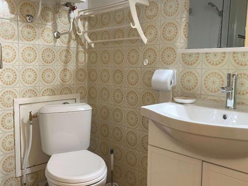 y baño con aseo blanco y lavamanos. en Studio Balaruc-les-Bains, 1 pièce, 2 personnes - FR-1-553-80, en Balaruc-les-Bains