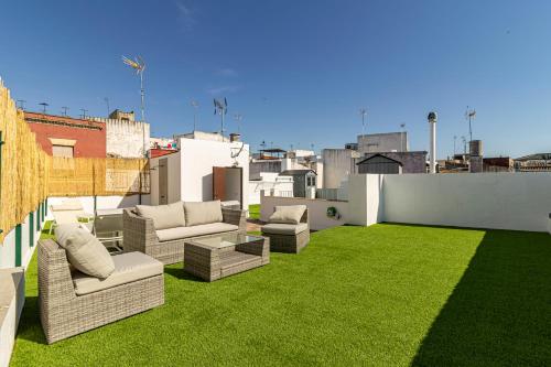a rooftop patio with grass and couches on a building at Allo Apartments Arroyo Catedral in Jerez de la Frontera