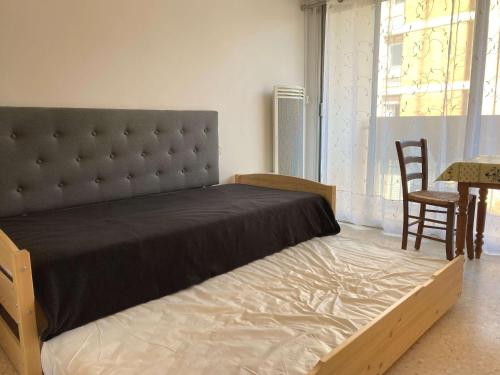 a bedroom with a large bed with a large window at Studio Balaruc-les-Bains, 1 pièce, 2 personnes - FR-1-553-26 in Balaruc-les-Bains