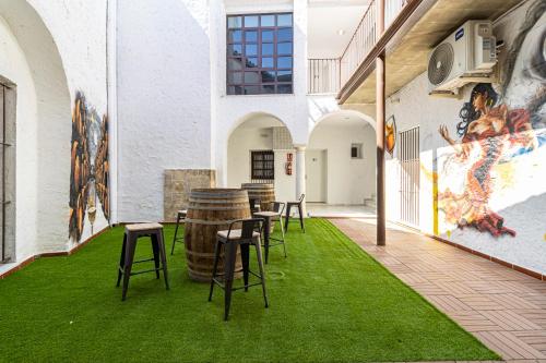 a room with chairs and a table with green grass at Allo Apartments Arroyo Catedral in Jerez de la Frontera