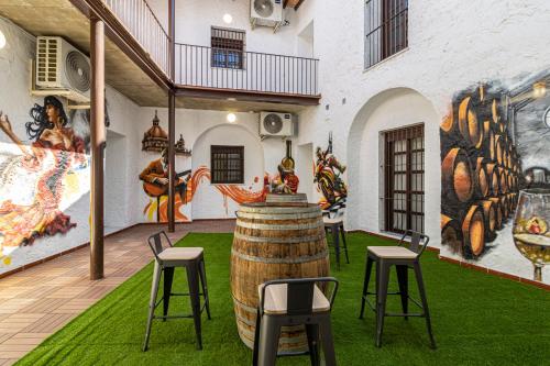 a room with a barrel and chairs and a mural at Allo Apartments Arroyo Catedral in Jerez de la Frontera