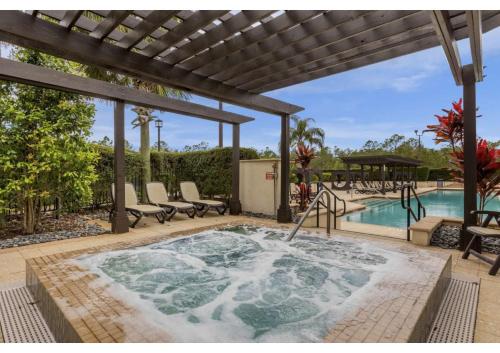 a hot tub on a patio next to a swimming pool at Sunny Summer Awaits - Renovated Townhome by Disney! in Orlando