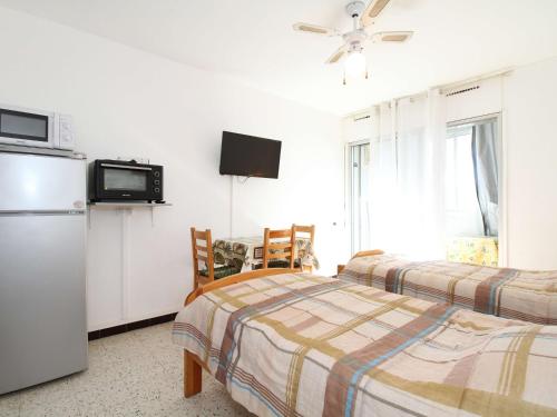 Cette chambre comprend deux lits et un réfrigérateur. dans l'établissement Charmant Studio avec Loggia - Exposition Sud/Est, Parc Charles de Gaulle, 2*, Equipé, Balaruc-les-Bains - FR-1-553-121, à Balaruc-les-Bains