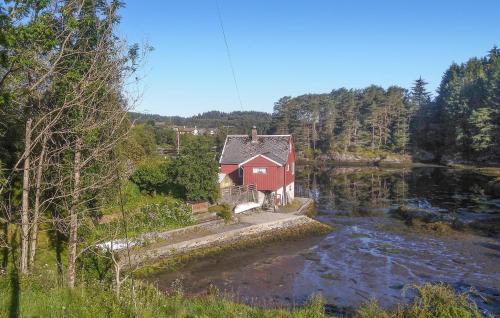 Gorgeous Home In Rossland With Wifi في Rossland: بيت احمر جالس على جانب النهر