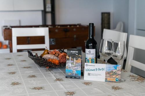 una mesa con una botella de vino y una cesta de copas de vino en GuestReady - Amazing holiday home near the beach en Vila Nova de Gaia