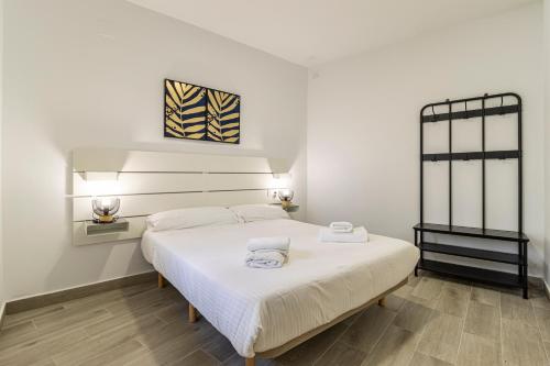 a bedroom with a bed with two towels on it at Allo Apartments Arroyo Catedral in Jerez de la Frontera