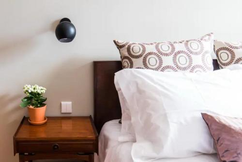 a bedroom with a bed with a wooden night stand with a table with a night at GuestReady - Rivoli Studio in Porto