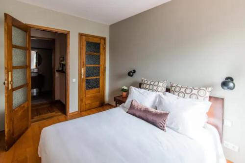 a bedroom with a large white bed with white pillows at GuestReady - Rivoli Studio in Porto