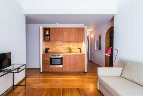 a living room with a couch and a kitchen at GuestReady - Rivoli Studio in Porto