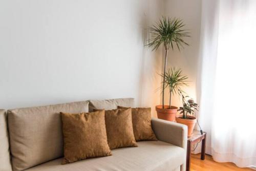 a living room with a couch and two potted plants at GuestReady - Rivoli Studio in Porto