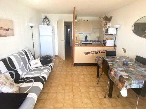 un salon avec un canapé et une table et une cuisine dans l'établissement Palavas : T2 Cabine en Front de Mer avec Balcon et Parking, Proche Centre et Commerces - FR-1-559-11, à Palavas-les-Flots