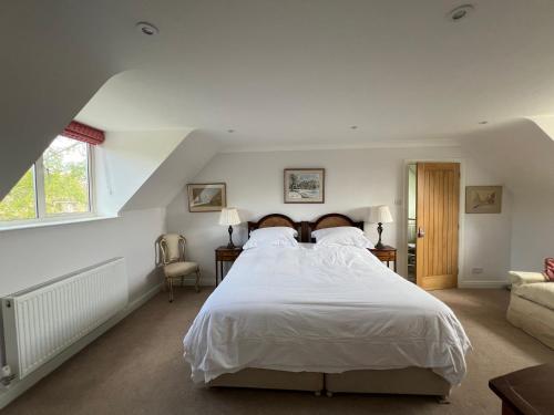Broadwell的住宿－Trinity House，卧室配有一张白色的大床和一张沙发。