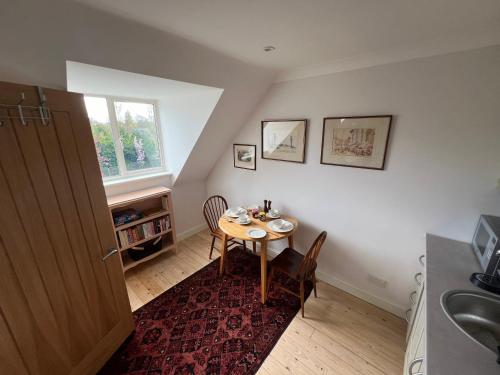 a small dining room with a table and a window at Trinity House in Broadwell