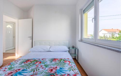 ein weißes Schlafzimmer mit einem Bett und einem Fenster in der Unterkunft 2 Bedroom Lovely Apartment In Barbat in Barbat na Rabu