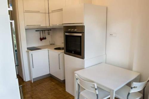 Il comprend une petite cuisine avec une table et un réfrigérateur blanc. dans l'établissement GuestReady - Cozy Boavista Studio 1B, à Porto