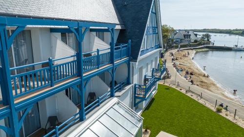 a building with blue balconies and a body of water at Best Western Plus Le Roof Vannes Bord de Mer in Vannes
